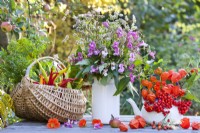 Arrangement floral et légumes récoltés sur la table, y compris le sarrasin, le baume de l'Himalaya, les lanternes chinoises et les baies de rowan.