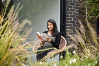 Meera, la propriétaire lisant un livre dans le jardin.