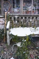 Table et banc enneigés dans un jardin en décembre.