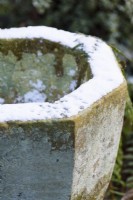 Neige recouvrant la surface d'un pot en pierre