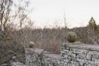 Sphères de pierre sur un mur à Cotswold Farm Gardens en février