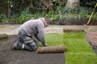 Un ouvrier posant un nouveau gazon lors de la rénovation d'un jardin londonien.