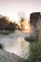 Le soleil du matin illumine la brume s'élevant des douves du palais épiscopal de Wells en janvier.