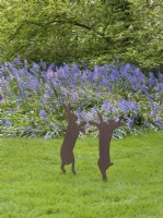 Ornements de lièvre dans la pelouse devant les jacinthes des bois