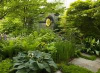 Un temple néo-classique entouré d'arbres et de plantes herbacées dans le Myeloma UK - A Life Worth Living Garden conçu par Chris Beardshaw au RHS Chelsea Flower Show 2023.