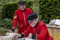 Chelsea retraité jouant aux échecs sur le London Square Community Garden, Designer : James Smith
