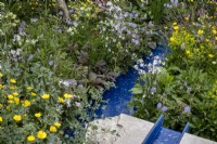 Le filet bleu en plastique recyclé est entouré de fleurs sauvages dont : Lychnis flos-cuculi 'White Robin', Geranium pratense et Ranunculus acris. Le jardin de la RSPCA, concepteur : Martyn Wilson.