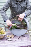 Femme remplissant les lacunes dans le pot avec du compost