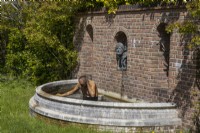 Une statue humoristique et une pièce d'eau. Trago Mills montrent les jardins, Devon, Royaume-Uni. Peut. Printemps