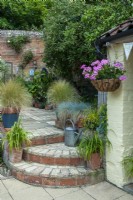 Patio de la cour avec des marches vers le niveau inférieur, la plantation en pot et le panier suspendu - Journée des jardins ouverts, Coddenham, Suffolk