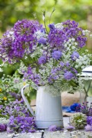 Bouquet à thème blanc violet dans un pichet contenant de l'allium, de la scabieuse des champs et de la berce du Caucase.