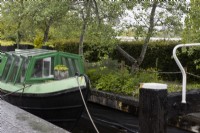 Jardin de Canal Street avec une vraie barge et une écluse à côté d'un parterre de fleurs et d'arbres. Trago Mills montrent les jardins, Devon, Royaume-Uni. Peut. Printemps
