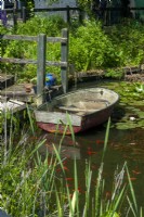 Bateau sur étang de jardin avec marches rustiques et main courante qui y mène - Journée des jardins ouverts, Shelfanger, Norfolk