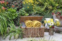 Harrods panier plein de couvertures dans un petit jardin de banlieue à Lichfield, Staffordshire, en rouge orange et jaune thème, juillet