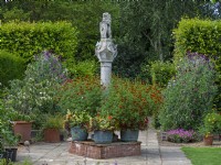 Le cadran solaire écossais et des pots en métal avec des soucis Old Vicarage Gardens East Ruston Norfolk Juillet Été