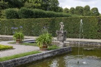 Hanovre Allemagne Jardins royaux de Herrenhausen. Inselgarten. Jardin de l'île. Avec des statues, une pièce d'eau avec une île et des agapanthes en pots.