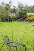 Chaises noires 'Airondack' pour enfants sur pelouse et parterres de fleurs de fin d'été