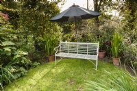 Banc en métal sous un parasol en août