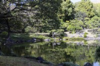 Le bord du lac Dai Sensui avec les reflets des arbres environnants.