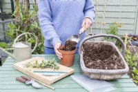 Femme remplissant un pot de compost