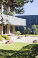 Gravier ratissé avec des roches placées connues sous le nom de karesansui avec des pins dans la zone appelée jardin de pierre. Vue sur l'hôtel.