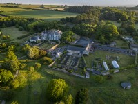 Vue aérienne de Mothecombe House dans le Devon, un bâtiment Queen Ann avec de vastes jardins situés dans la campagne vallonnée du Devon