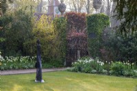 Planté dans le parterre de gauche, Tulipa 'Green Star' et 'Spring Green'. Planté dans le parterre de droite, Tulipa 'Catherina' et 'Hakuun'. La statue sur la pelouse est « Looking Good, Looking Fine » d'Elizabeth Sinclair. Dans le jardin élisabéthain, Pashley Manor.