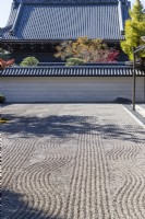 Une partie du jardin zen principal en gravier ratissé appelé karesansui qui se traduit par « eau sèche de montagne ». Vue sur les arbres et autres bâtiments à l'extérieur du jardin.