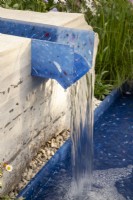 Un ruisseau à eau moderne et contemporain fabriqué à partir de plastiques recyclés sertis dans la pierre