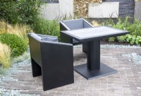 Patio pavé de briques avec table et chaises noires 