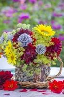 Bouquet de fleurs avec fenouil, échinops, dahlia et hélianthus dans une tasse de thé à l'écorce et à la mousse faite maison. 