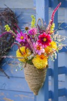 Bouquet de fleurs d'été avec Dahlia, Monarda, Echinacea purpurea, persicaria amplexicaulis, Verbascum et Amaranthus caudatus dans un vase suspendu en corde. 