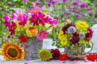 Bouquets de fleurs d'été dans un vase en boîte de conserve et une tasse de thé à l'écorce et à la mousse faites maison. Contenant Cosmos, Dahlia, Echinops, Helianthus et Fenouil. 