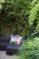 Canapé d'angle dans une zone isolée du jardin avec bambou 