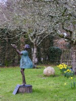 Sculpture de jardin en métal bronze « Matilda » dans un verger de RHS Rosemoor, février. 