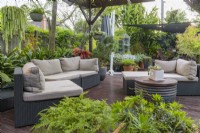 Espace de divertissement extérieur comprenant des plantes en pot et du mobilier d'extérieur. 