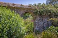 En regardant vers l'arche du jardin de mosaïque dans le jardin de la grange de Great Dixter 
