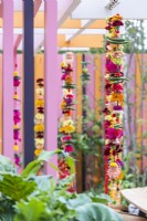 Guirlandes de soucis composées de fleurs, piments, fruits, pompons et bracelets 