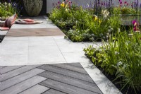 Un trottoir dans un jardin moderne composé de matériaux mixtes et entouré de parterres de fleurs vivaces. Créateur : Kevin Dennis, Bord Bia Bloom 2023 