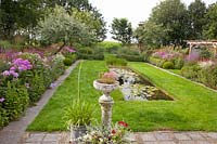 Jardin avec bassin, plantes vivaces, pelouse 