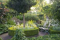 Salon de jardin avec couvre-sol, arbres, coin salon 