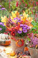 Arrangement automnal avec feuilles, pommetier, bruyère, Pfaffenhütchen et Aster dumosus Purple Dome 