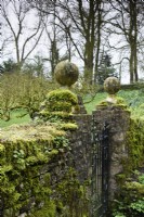Poteaux moussus dans le jardin clos de Cerney House en mars 