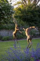 Statue 'Boxing Hares' de Miranda Michels avec Nepeta racemosa 'Walker's Low' 