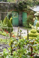 Porte peinte en vert dans le jardin clos de l'abbaye de Hartland en avril 
